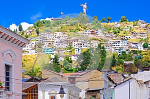 Outdoor view of colonial buildings houses located in the city of Quito with the statue of Virgin of Panecillo in the