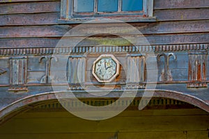 Outdoor view of facade of woden structure with a clock painted located on Lemuy Island, is one of the Churches of Chilo photo