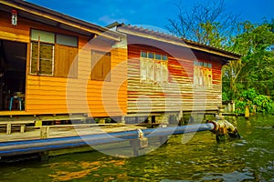 Outdoor view of gorgeous floating wooden house with a pipeline on the Chao Phraya river. Thailand, Bangkok