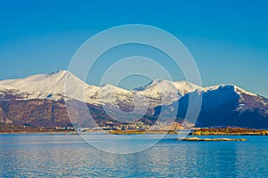 Outdoor view of mountain range in Norway. The beautiful mountain covered partial with snow in Hurtigruten region in