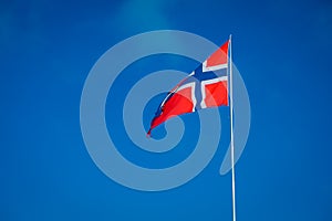 Outdoor view of Norwegian flag with a beautiful blue sky