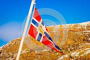 Outdoor view of Norwegian flag waving with a beautiful blue sky background