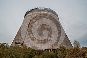 Outdoor view of old abandoned grading cooling thermal tower near nuclear plant located in the Chernobyl ghost town