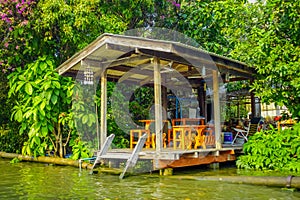 Outdoor view of pipeline close to a wooden building on the Chao Phraya river. Thailand, Bangkok