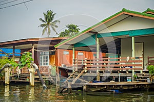 Outdoor view of pipeline crossing in fornt of a wooden poor house on the Chao Phraya river. Thailand, Bangkok