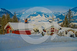 Outdoor view of red wooden typical housecovered with snow in the roof in GOL