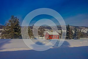 Outdoor view of red wooden typical housecovered with snow in the roof in GOL