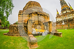 Outdoor view of stoned budha with a yellow fabric and dome behind at Wat Pra. It was the holiest temple of the city