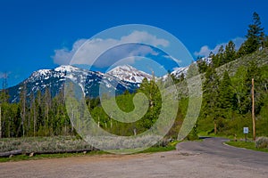 Outdoor view of stoned highway leading to the Grand Teton National Park, Wyoming, in a gorgeous sunny day with mountains