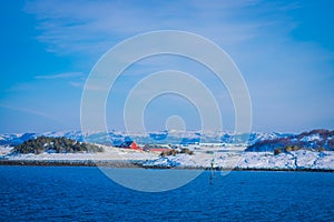 Outdoor view of wooden houses a long in the coast from Hurtigruten voyage cruise ship, Northern Norway