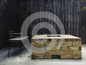 An outdoor vintage brick fireplace with bench on wood plank wall background