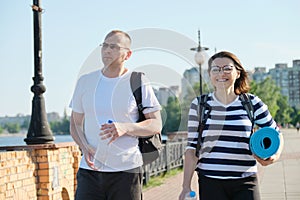Outdoor walking man and woman, talking people, middle-aged couple