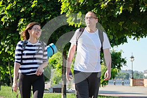 Outdoor walking man and woman, talking people, middle-aged couple