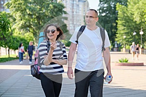 Outdoor walking man and woman, talking people middle-aged couple