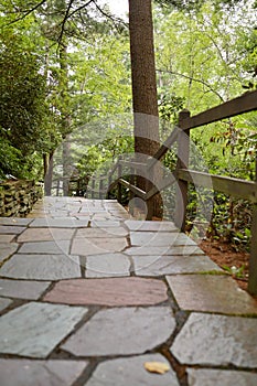 an outdoor walkway with many stone steps leads down the side of a hill