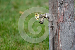 Outdoor water spigot fountain attached to a wooden porch, useful for campers