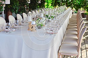 Outdoor wedding celebration at a restaurant. Festive table setting, catering. Wedding in rustic style in summer