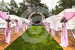 Outdoor wedding ceremony with umbrellas in the forest