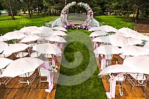 Outdoor wedding ceremony with umbrellas in the forest