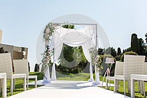 Outdoor wedding ceremony. Wedding chuppa decorated with fresh flowers