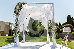Outdoor wedding ceremony. Wedding chuppa decorated with fresh flowers