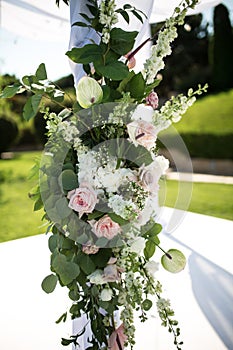 Outdoor wedding ceremony. Wedding chuppa decorated with fresh flowers