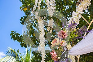 Outdoor wedding ceremony. Wedding decoration with flowers. Wedding floral arch with bouquet in garden. Marriage concept.