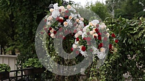 Outdoor wedding decor showcases elegant floral arrangements with roses, greenery on aisle, romantic setting for nuptials