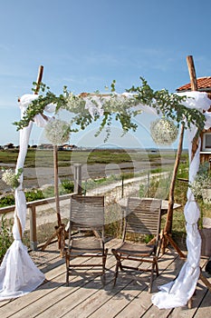 Outdoor wedding reception with arch on the shore of sea in arcachon bassin in france