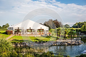 Outdoor wedding reception in tent in garden.