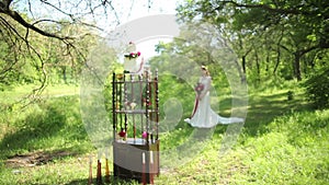 Outdoor Wedding table decorations and young bride with a beautiful wedding bouquet of flowers in hands