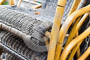 Outdoor wicker chairs after rain with raindrops