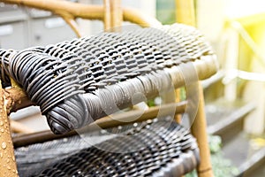 Outdoor wicker chairs after rain with raindrops. The sun shines after the rain
