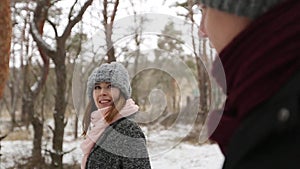 Outdoor winter forest shot of young wedding couple walking and having fun holding hands in snow weather pine forest