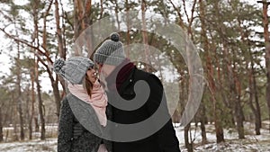 Outdoor winter forest shot of young wedding couple walking and having fun holding hands in snow weather pine forest