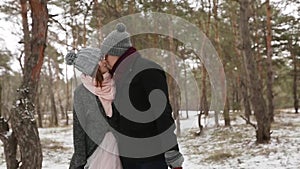 Outdoor winter forest shot of young wedding couple walking and having fun holding hands in snow weather pine forest