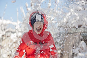 Outdoor winter portrait of little healthy happy baby child walking in the park on cold day with snow and snowfall. Selective focus