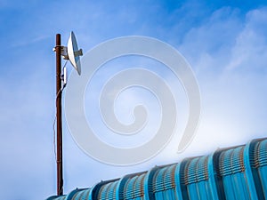 Outdoor wireless access point on the rusty pole with blue sky view background.