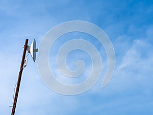 Outdoor wireless access point on the rusty pole with blue sky view background.