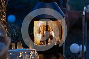 Outdoor wood stove with burning open fire