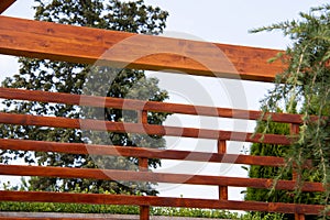 Outdoor wooden pergola, lines of wood in detail and blue sky  and nature on background