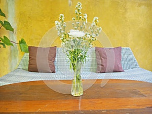 Outdoor wooden table and flowers in a vase