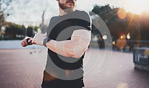 Outdoor Workout lifestyle concept. Young man stretching his body muscles before training. Muscular athlete wearing smart