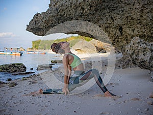 Outdoor yoga practice. Anjaneyasana, Low Lunge Pose. Slim Caucasian woman practicing yoga on the beach. Stretching exercise.