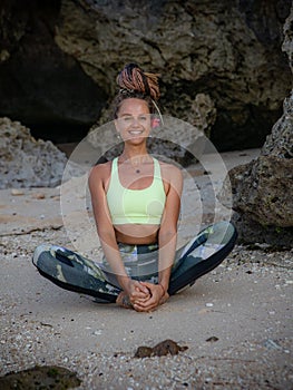 Outdoor yoga practice. Badhakonasana, Butterfly Pose. Attractive woman practicing yoga on the beach. Healthy lifestyle. Self care
