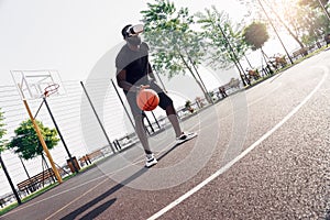Outdoors Activity. African man in vr headset playing basketball on court concentrated watching video