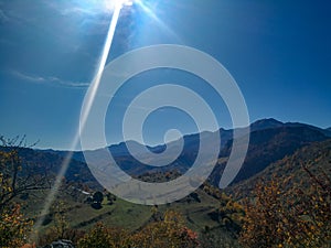 Outdoors beautiful view of sunshine falling on mountains, hills, meadows and fields on autumn fall day in colorful relaxing nature