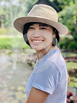 Outdoors close up portrait of girl smiling or asian woman smiling in the park and looking at camera