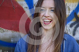 Outdoors closeup of beautiful smiling girl with brown hair and red lips.