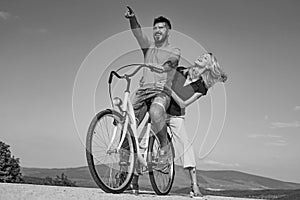 Outdoors. Feeling and emotion. Married couple. Couple riding bicycle on sunny day. Couple in love riding a bike.